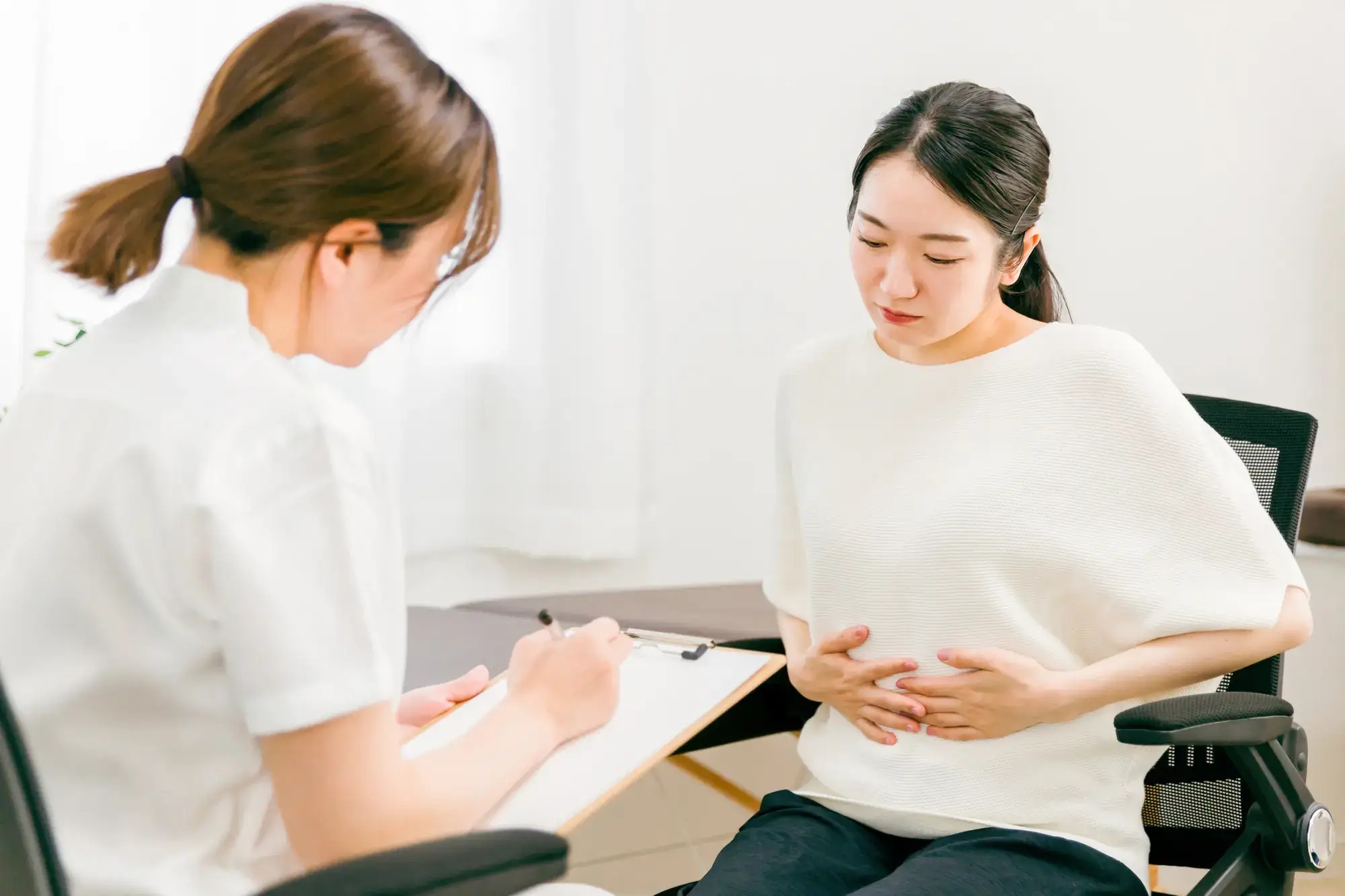 お腹に不調のある患者を問診しているところ